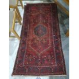 Eastern style rug, red ground with orange, blue and white decoration 200 x 100cm