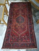 Eastern style rug, red ground with orange, blue and white decoration 200 x 100cm