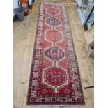 Vintage Persian Heriz runner, the pink ground with five hooked medallions and stepped border,