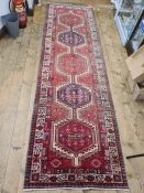 Vintage Persian Heriz runner, the pink ground with five hooked medallions and stepped border,