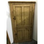 Late 19th century pine corner cupboard with two cupboard doors enclosing shelves, on plinth base,