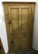 Late 19th century pine corner cupboard with two cupboard doors enclosing shelves, on plinth base,