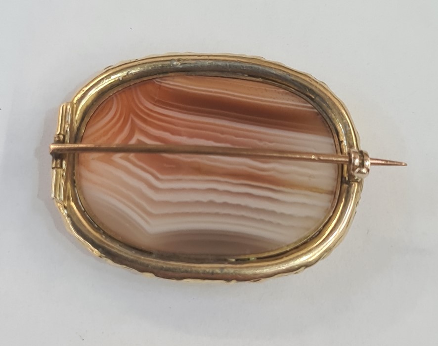 Early Victorian gilt metal brooch set with a central cabochon agate within a chased floral border, - Image 2 of 2
