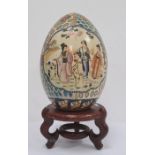 Japanese ceramic egg-pattern centrepiece, ovoid and decorated with panels of figures on a brocade