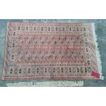 Persian style rug with pink ground, elephant's foot guls, blue and red border, 147cm x 95cm