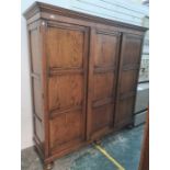 20th century oak three-door wardrobe with cavetto moulded cornice above the panelled doors, with