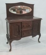 20th century sideboard with oval mirrored back above two central drawers and two cupboard doors,