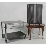 Modern two-tier low hostess trolley / tv stand on castors in black and chrome, on four castors, a