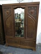 Early 20th century oak wardrobe, the central mirrored section flanked by cupboard doors, on base