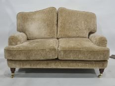 Two-seat Laura Ashley sofa in pale gold coloured upholstery, turned supports to brass caps and