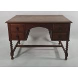 Early 20th century oak desk with four drawers, on barleytwist and block supports to stretchered