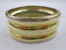 1980's Yves St Laurent gold-coloured cuff, ribbed and hinged, skin pattern interior and bearing '