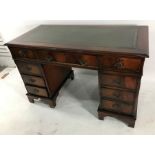 20th century pedestal desk with green leather inset top above nine assorted drawers, on bracket