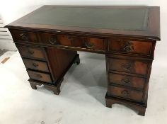 20th century pedestal desk with green leather inset top above nine assorted drawers, on bracket