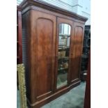 19th century mahogany compactum, the moulded cornice above three cupboard doors, the central and