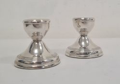 Pair of 20th century silver-mounted squat candlestick holders, reeded decoration, on circular bases,