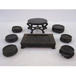 Quantity of Oriental hardwood stands and an oval lidded box with hammered decoration