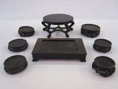 Quantity of Oriental hardwood stands and an oval lidded box with hammered decoration