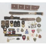 Collection of British cap badges, naval badges and rank markings, one box and a WWII machete