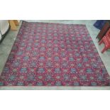 Large modern machine made red ground rug with all-over repeating green and blue pattern, 205 x