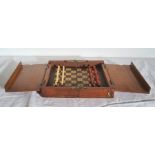 A travel chess board, with one set of pieces stained red, one white, 20.2cm