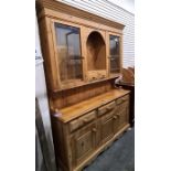 20th century pine dresser with ogee moulded pediment above two glazed doors flanking central