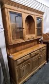 20th century pine dresser with ogee moulded pediment above two glazed doors flanking central