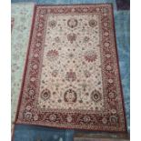 Modern machine-made cream ground rug with red foliate border, 237 x 162cm