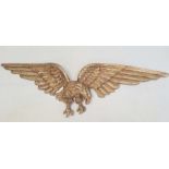 Gilt metal spread-eagle wall plaque, 109cm wide
