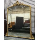 Large 20th century overmantel mirror with arched top, surmounted by putto amongst scrolling