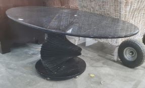 Modern glass coffee table, the oval top on stepped spiralling pedestal, to circular base, 118cm wide