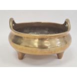 Chinese bronze censer circular, bulbous and two handled on three tab feet, 27cm diameter (four