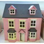 A pink dolls house with bay windows, lift up roof, hinged front, 62cm high and a large quantity of