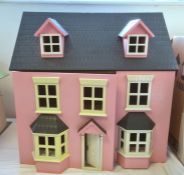 A pink dolls house with bay windows, lift up roof, hinged front, 62cm high and a large quantity of