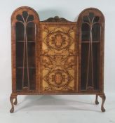 Early 20th century walnut cabinet, the double domed top with central shelf above fall, drawer and
