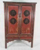 Chinese-style marriage cabinet painted black and red, two doors enclosing various shelves and