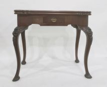 A George III taste mahogany card table, Irish, the shaped top opening to reveal green baize and