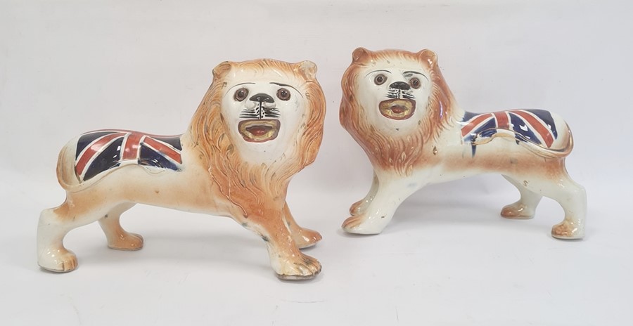 Pair of Staffordshire-style pottery lions painted with Union Jacks, 25cm high x 32cm long (2)