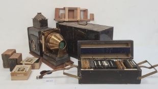 Antique brass black japanned metal magic lantern in metal carrying case and large quantity of