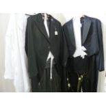 Vintage tail suit in very dark blue, with white waistcoat and trousers with braces, a black tail