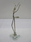 Contemporary silver-coloured sculpture, praying mantis-type model, on a square clear plastic base,