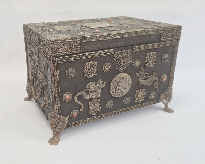 Eastern wooden casket of rectangular form, the body and hinged cover decorated with applied metal