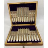 An early 20th century set of silver and mother of pearl handled dessert knives and forks, 12 person,