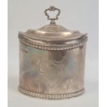 An Edwardian oval silver tea caddy with gilt interior, scroll handle, egg and dart edges, with