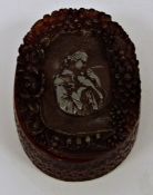 Amber-coloured box of oval form, signed to base 'J Guipt of Paris', with carved decoration to the