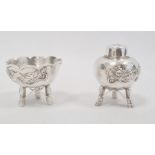 A silver pepperette and matching salt, Chinese decorated with dragon in relief on a hammered ground,