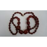 Cherry amber graduated beaded necklace, the largest bead 3cm x 2.2cm approx., the smallest 1.1cm x