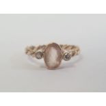 9ct gold, pale orange stone and diamond three-stone ring, the central oval pale orange stone 8mm x