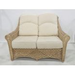 Modern conservatory-type sofa with wicker frame with cream-coloured cushions Condition
