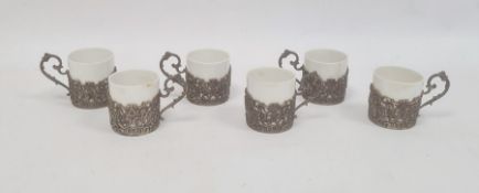 Set of six German silver coffee can holders, each decorated with a panel of cherubs within scrolling